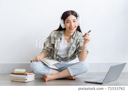 Beautiful Asian girl studying online at home Beautiful Asian girl studying online at home 71553762