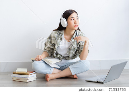 Beautiful Asian girl studying online at home Beautiful Asian girl studying online at home 71553763