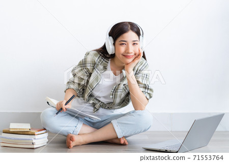 Beautiful Asian girl studying online at home Beautiful Asian girl studying online at home 71553764