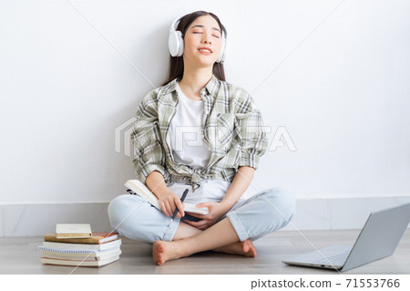 Beautiful Asian girl studying online at home Beautiful Asian girl studying online at home 71553766