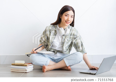 Beautiful Asian girl studying online at home Beautiful Asian girl studying online at home 71553768