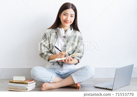 Beautiful Asian girl studying online at home 71553770