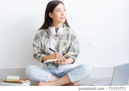 Beautiful Asian girl studying online at home Beautiful Asian girl studying online at home 71553771