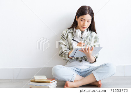 Beautiful Asian girl studying online at home Beautiful Asian girl studying online at home 71553773