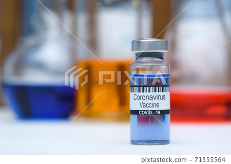 Coronavirus vaccine in bottle for injection on table against background medical laboratory, space for text. Defeating SARS-CoV-2 coronavirus epidemic. Scientists have found vaccine against coronavirus 71555564