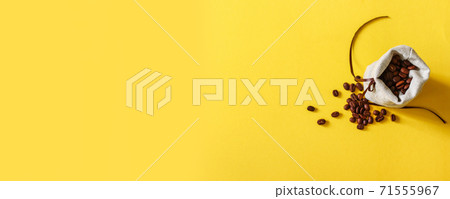 Horizontal sale banner of grains of aromatic brown coffee in a burlap bag and scattered on a yellow table Horizontal sale banner of grains of aromatic brown coffee in a burlap bag and scattered on a yellow table 71555967
