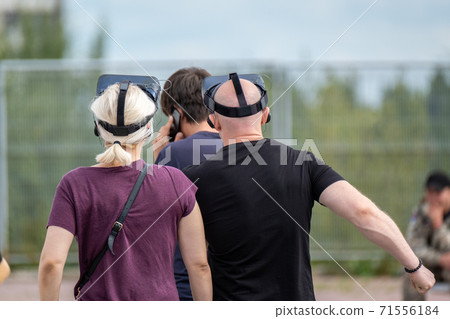Unrecognizable people in VR goggles on street Unrecognizable people in VR goggles on street 71556184