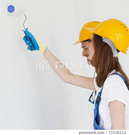 Two workers painting the wall 71556213