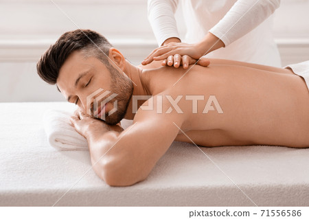 Relaxed man having manual therapy session at spa Relaxed man having manual therapy session at spa 71556586