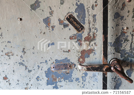 Grungy steel door fragment with manual lock 71556587