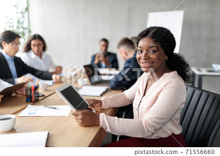 African American Businesswoman Using Tablet On Corporate Meeting In Office African American Businesswoman Using Tablet On Corporate Meeting In Office 71556660