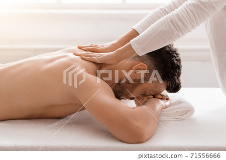 Side view of relaxed man having body massage at spa Side view of relaxed man having body massage at spa 71556666
