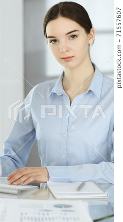 Business woman working with computer at the glass desk in modern office. Student girl preparing presentation or bookkeeper making balance. Tax and audit concept Business woman working with computer at the glass desk in modern office. Student girl preparing presentation or bookkeeper making balance. Tax and audit concept 71557607