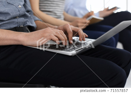 Group of casual dressed business people working at meeting or conference, close-up of hands. Businessman using laptop computer. Teamwork or coaching concept 71557857