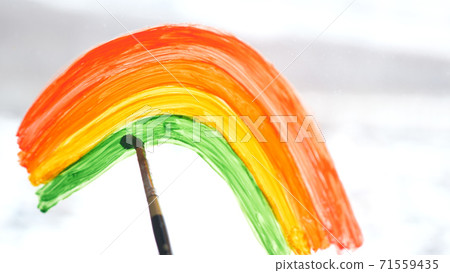 a woman's hand painting rainbow during Covid-19 quarantine at home. Stay at home Social media campaign for coronavirus prevention, let's all be well, hope during coronavirus pandemic concept a woman's hand painting rainbow during Covid-19 quarantine at home. Stay at home Social media campaign for coronavirus prevention, let's all be well, hope during coronavirus pandemic concept 71559435