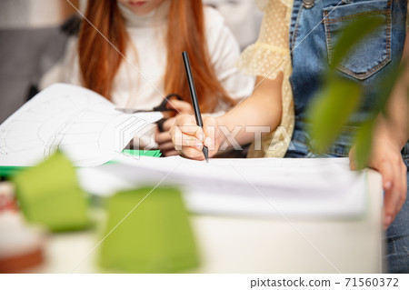 Close up hands of two little children, girls together in creativity of the house. Kids make handmade toys for games or New Year celebration Close up hands of two little children, girls together in creativity of the house. Kids make handmade toys for games or New Year celebration 71560372