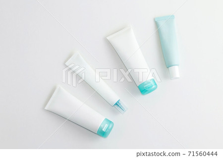 Set of white and turquoise blue cosmetics containers on light background. Copy space. Flat lay. Set of white and turquoise blue cosmetics containers on light background. Copy space. Flat lay. 71560444