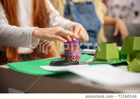 Close up hands of two little children, girls together in creativity of the house. Kids make handmade toys for games or New Year celebration Close up hands of two little children, girls together in creativity of the house. Kids make handmade toys for games or New Year celebration 71560548