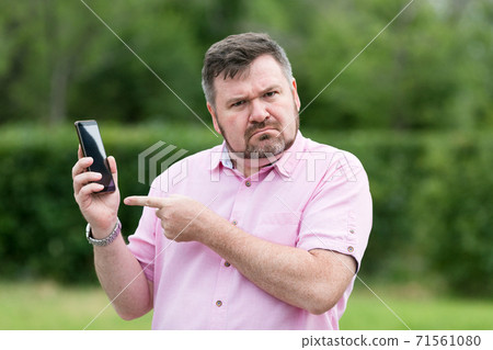 A man in disbelief from a phone call A man in disbelief from a phone call 71561080