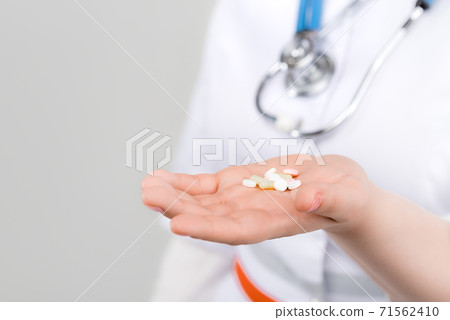 Photo of doctor with drugs in hands on light background 71562410