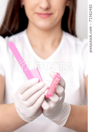 Manicure tools in hands of manicurist 71562492