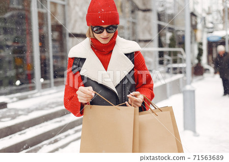 Woman carrying shopping bags at an outdoor shopping mall 71563689