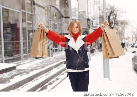 Woman carrying shopping bags at an outdoor shopping mall Woman carrying shopping bags at an outdoor shopping mall 71563748