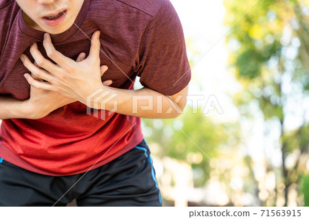 Exhausted male runner athlete suffering painful angina pectoris or asthma breathing problems while running in the park. Exhausted male runner athlete suffering painful angina pectoris or asthma breathing problems while running in the park. 71563915