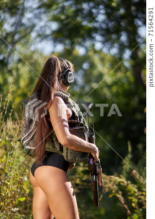 side view on sportive hunter woman in shorts looking away 71564291
