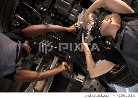two mixed race auto mechanic males have successful work 71565538
