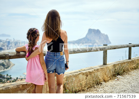 Rear view mother hug daughter outdoors Rear view mother hug daughter outdoors 71567539