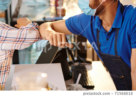 Elbow bump with coffeeshop barista 71568018