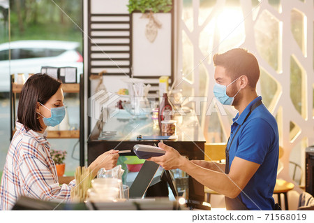 Woman paying for order in cafe Woman paying for order in cafe 71568019