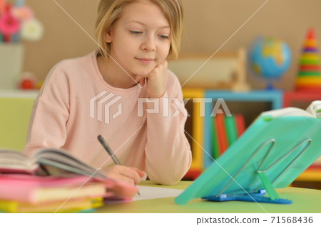 Portrait of little cute girl doing homework Portrait of little cute girl doing homework 71568436