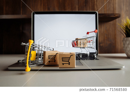Paper boxes in supermarket carts on a laptop keyboard. Online shopping and delivery concept 71568580