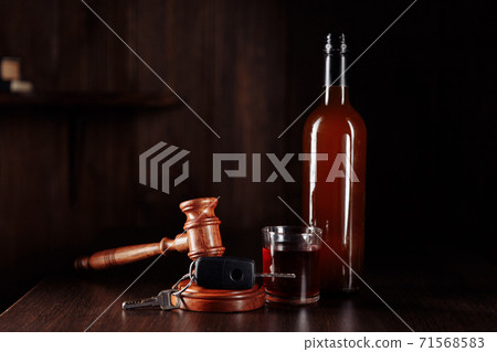 Car key, judge gavel and whiskey alcohol drink in a glass on a wooden table. Don't drink and drive abstract concept 71568583