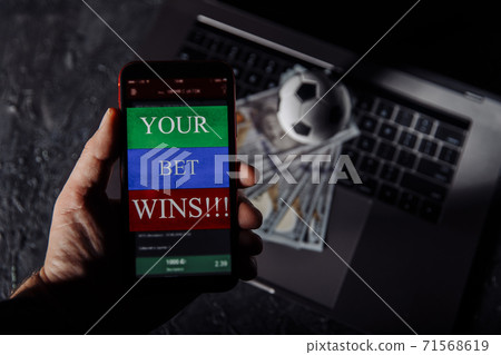 Man holding smartphone with winning result of his bet Man holding smartphone with winning result of his bet 71568619
