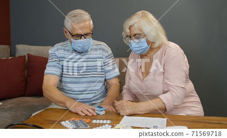 Senior couple grandfather and grandmother monitoring oxygen saturation with digital pulse oximeter Senior couple grandfather and grandmother monitoring oxygen saturation with digital pulse oximeter 71569718