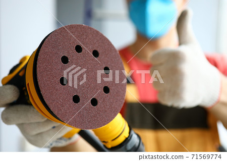 Sandpaper in hands of handyman in protective mask 71569774