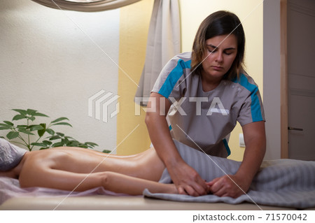 The caucasian masseur does a hand massage by rubbing the muscles. The caucasian masseur does a hand massage by rubbing the muscles. 71570042