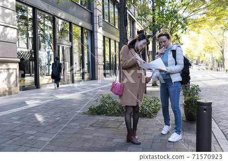 A Japanese woman asked by a foreign woman while walking in the city A Japanese woman asked by a foreign woman while walking in the city 71570923