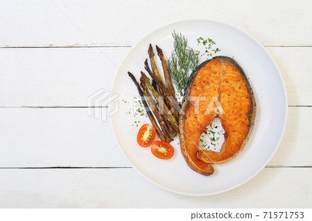 Salmon Steak in white dish and have baked asparagus. Salmon Steak in white dish and have baked asparagus. 71571753