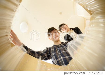 母女倆打開通過郵購購買的產品（從內部查看） 71572240