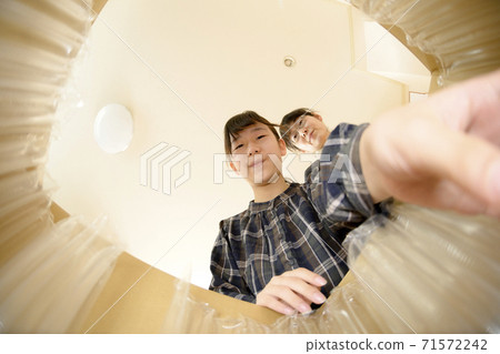 母女倆打開通過郵購購買的產品(從內部查看) 母女倆打開通過郵購購買的產品(從內部查看) 71572242