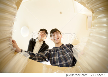 母女倆打開通過郵購購買的產品(從內部查看) 母女倆打開通過郵購購買的產品(從內部查看) 71572243