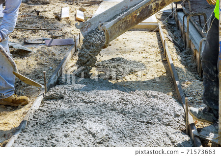 Laying down a new sidewalk in wet concrete on freshly poured sidewalks 71573663