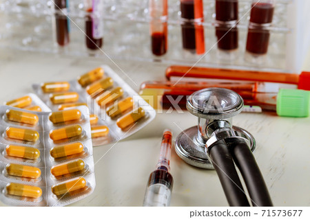 Health care with stethoscope and pills glass tube with blood HIV, AIDS, LDL, HDL test 71573677