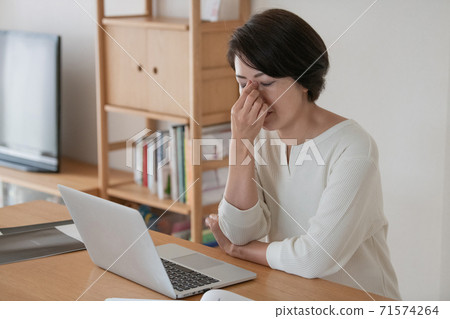 Women who feel tired from teleworking and working from home 71574264