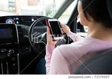 開車時操作智能手機的女人 71574437