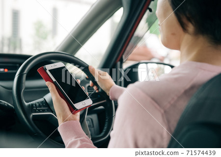 開車時操作智能手機的女人 71574439